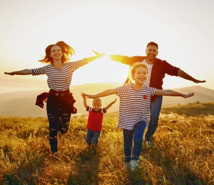 Happy family: mother, father, children son and daughter on sunse