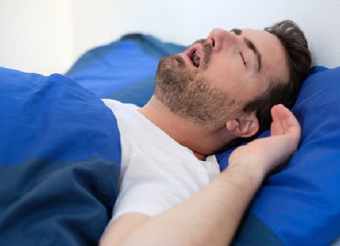 Man in bed snoring and suffering for sleep apnea syndrome